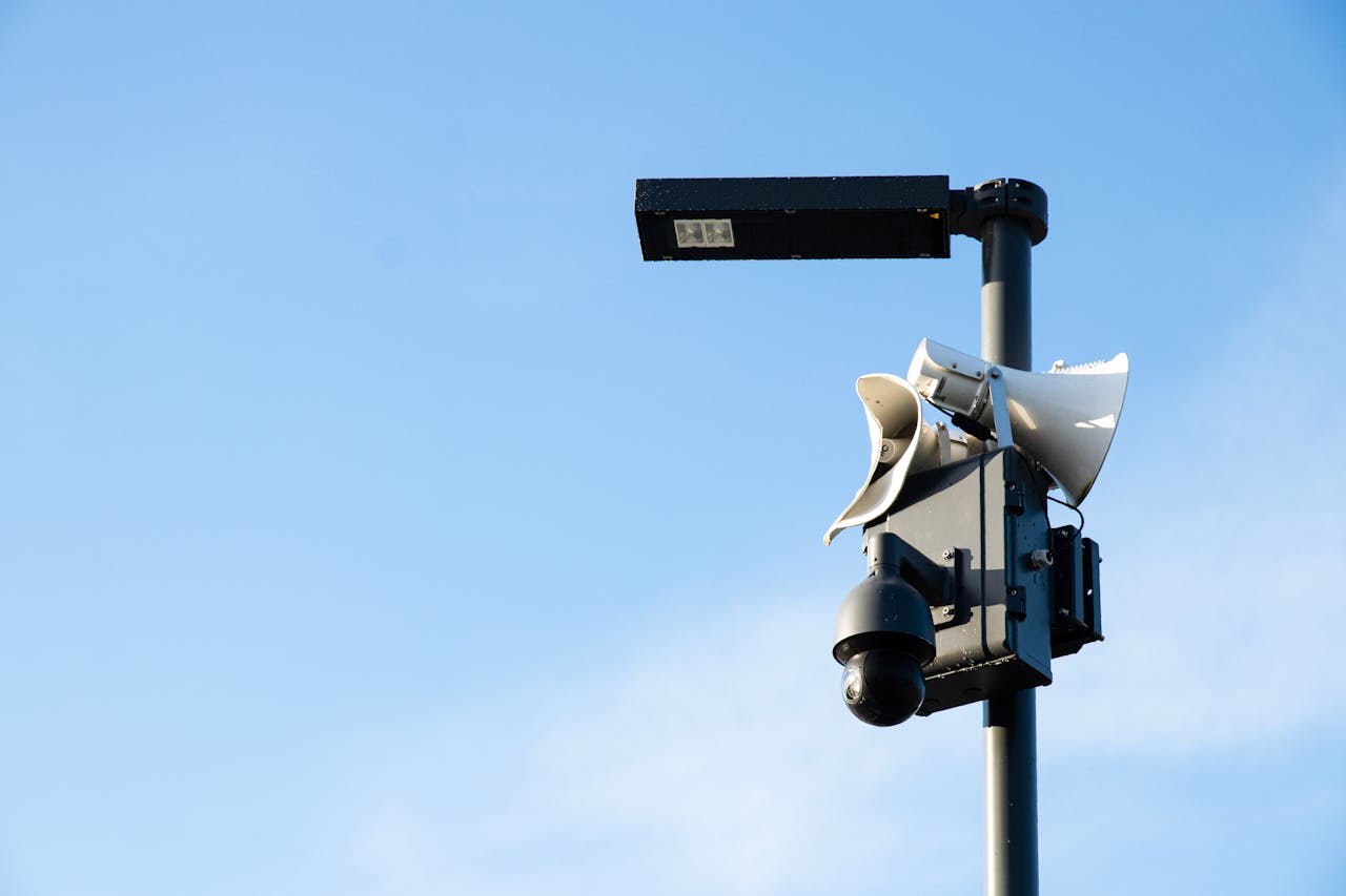 about-06 Street lamp post with security camera and speakers under a blue sky in Jūrmala, Latvia.