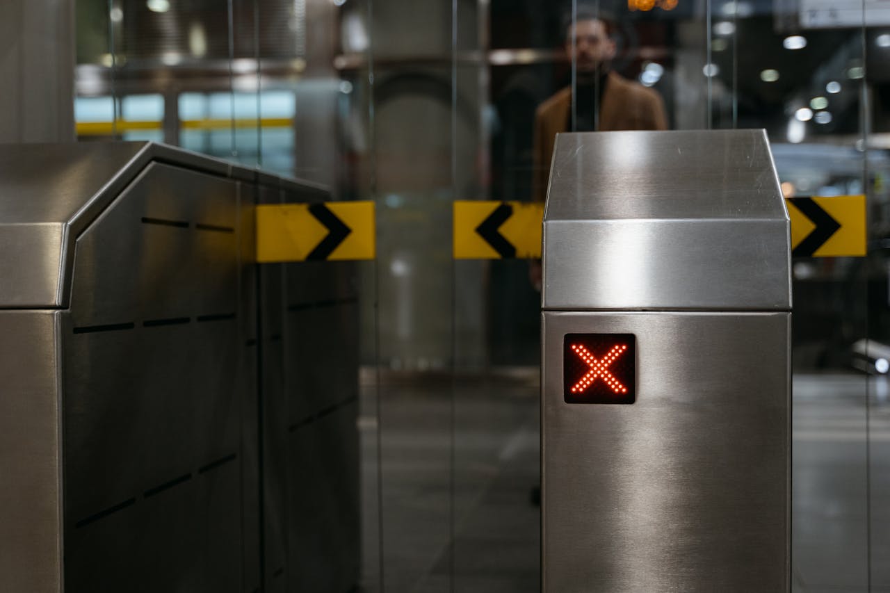 about-07 Close-up of a stainless steel ticket barrier with red X signal indicating no entry.